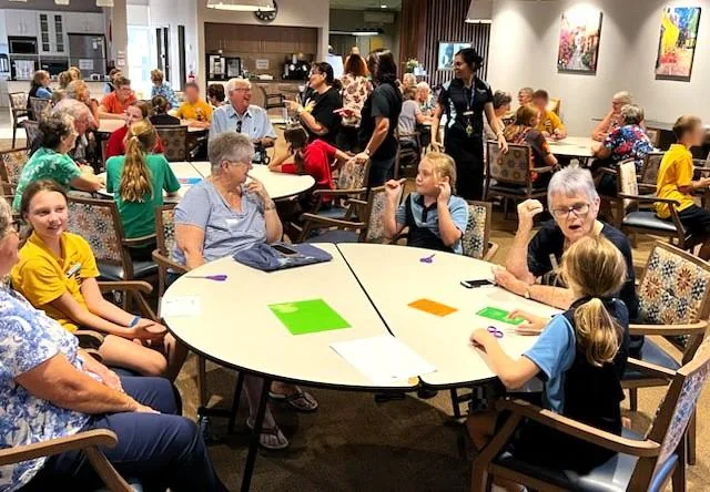 Des habitants réunis autour de tables, lors d’une rencontre de l’association